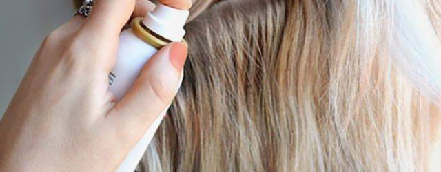 Blonde woman spraying dry shampoo